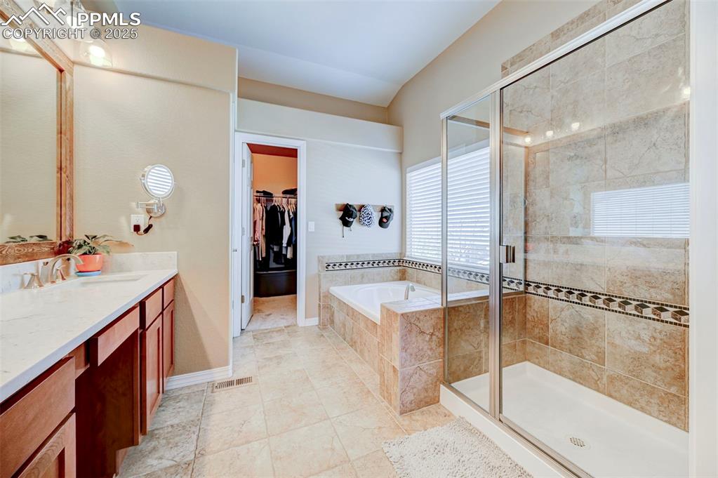 Image 20 of 31: Bathroom with a bath, vanity, visible vents, and a stall shower