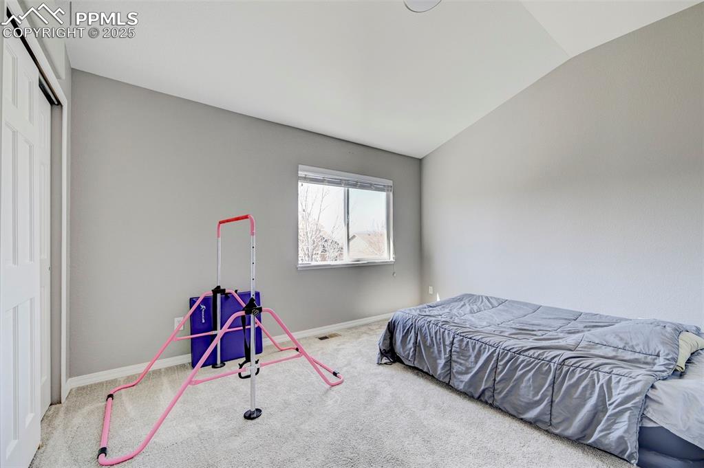 Image 25 of 31: Bedroom with carpet, vaulted ceiling, visible vents, a closet, and baseboar