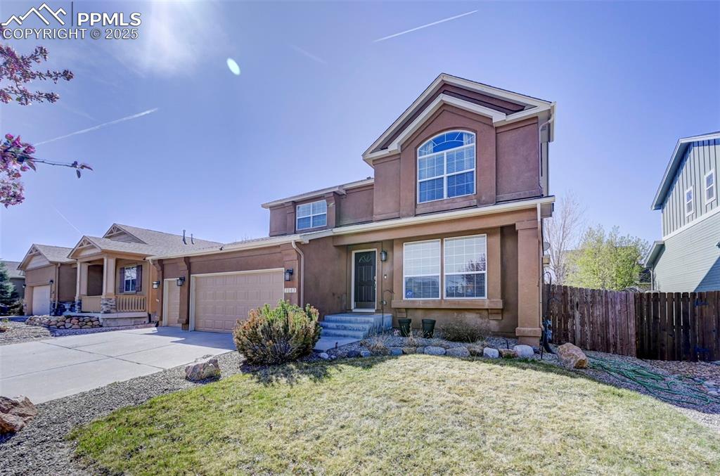 Image 3 of 31: Traditional-style house featuring a front lawn, driveway, fence, a garage, 