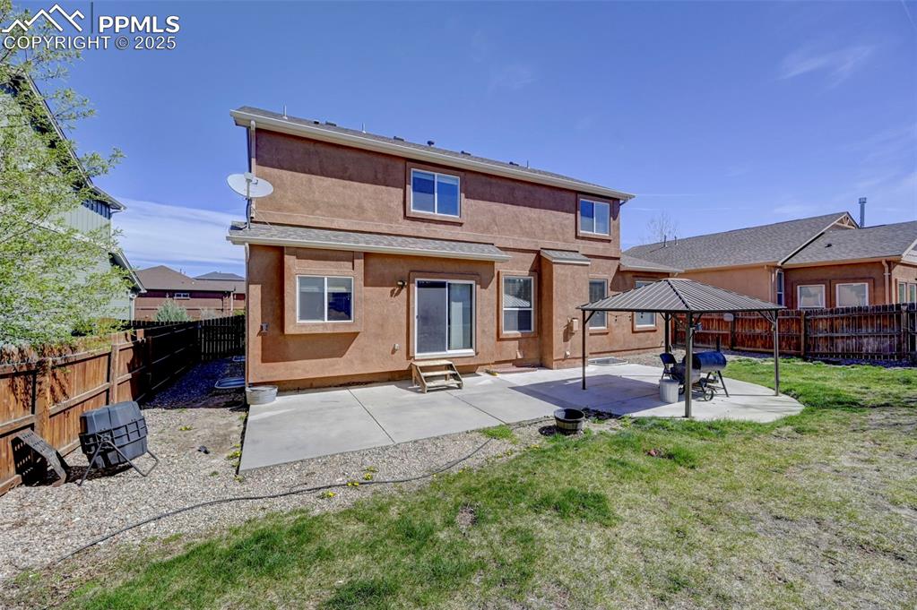 Image 30 of 31: Back of property featuring a fenced backyard, entry steps, a yard, and a pa
