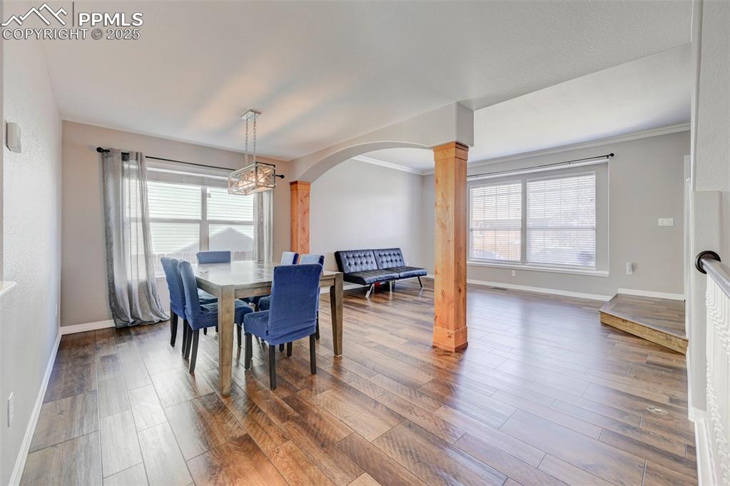 Image 5 of 31: Dining space featuring wood finished floors, a chandelier, arched walkways,