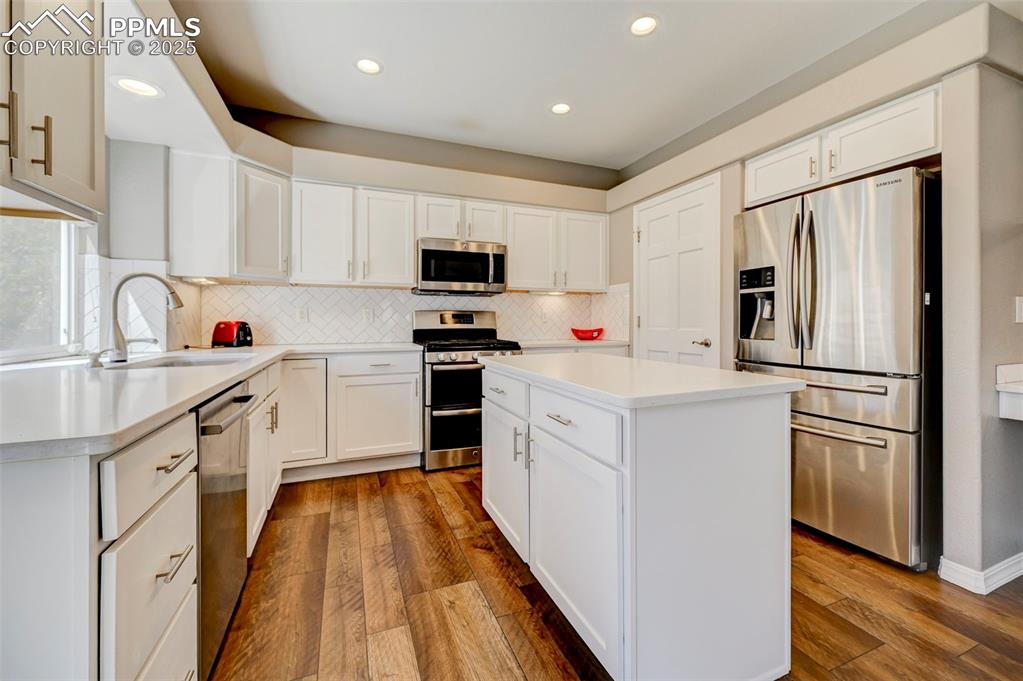 Image 7 of 31: Kitchen featuring stainless steel appliances, a sink, recessed lighting, wo