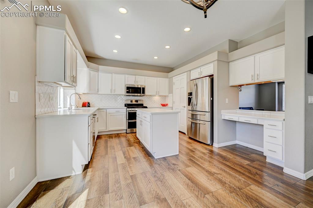 Image 8 of 31: Kitchen featuring a sink, recessed lighting, decorative backsplash, light c