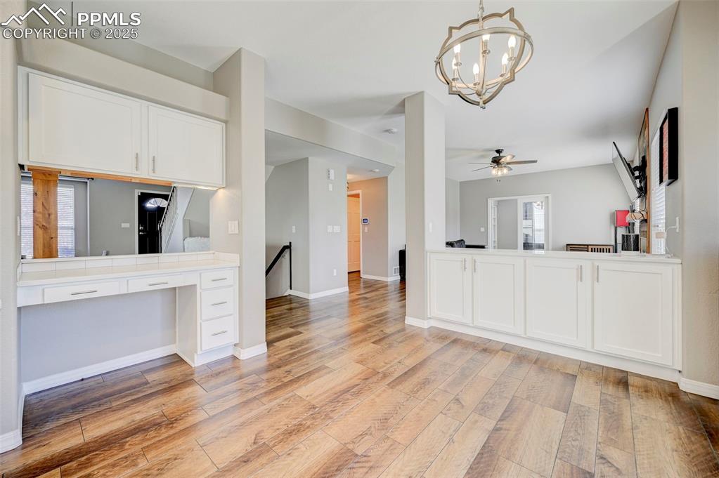 Image 9 of 31: Kitchen featuring light wood finished floors, baseboards, white cabinetry, 