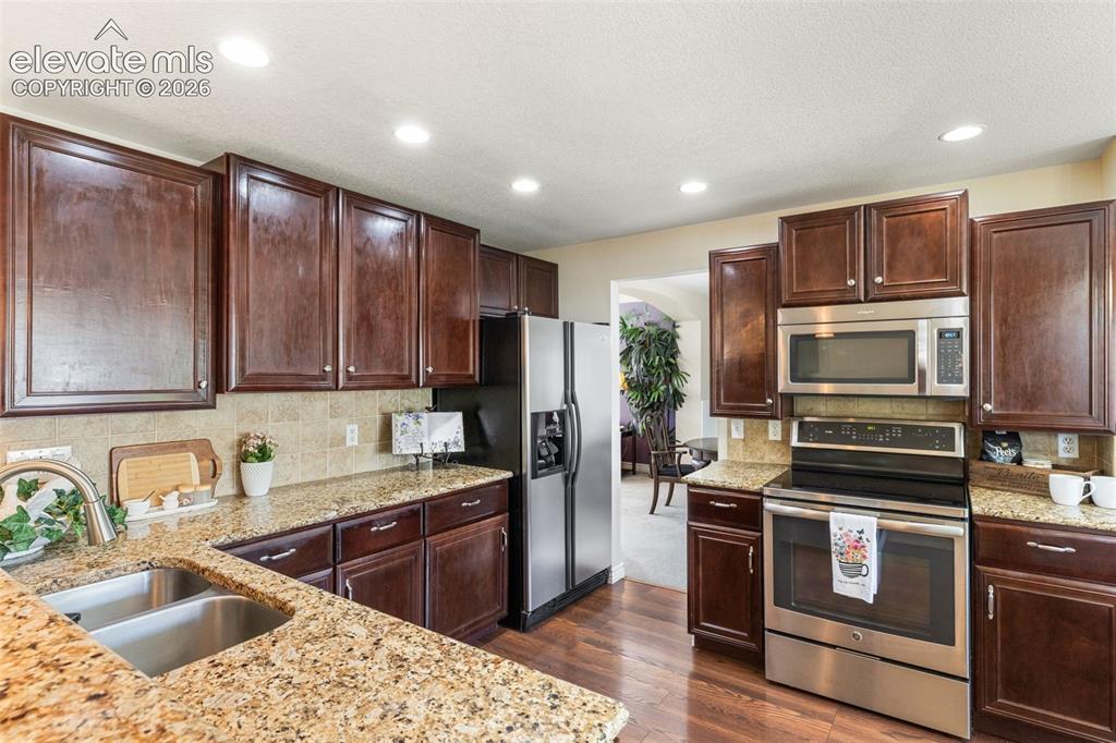 Image 10 of 47: Granite countertops, stainless steel appliances.