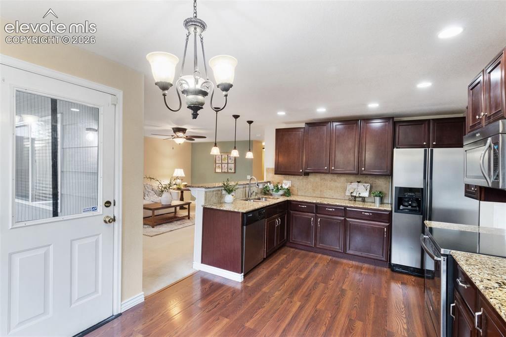 Image 12 of 50: Covered patio access from kitchen, open to family room