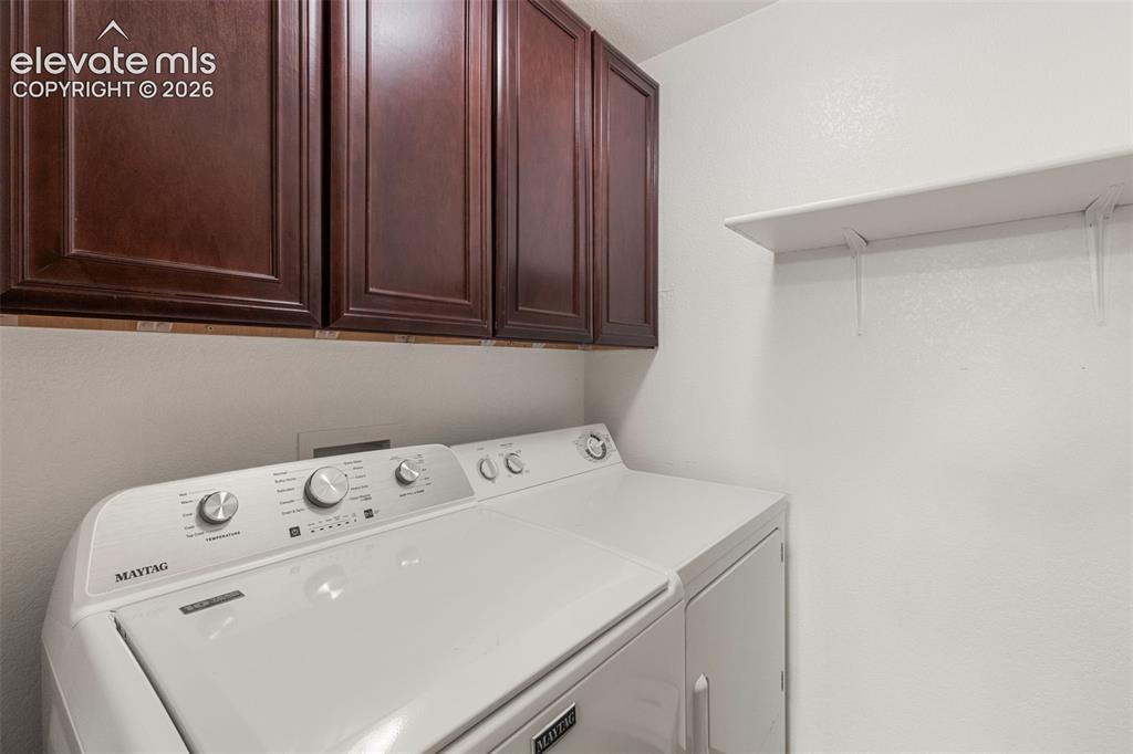 Image 18 of 47: Main level laundry room with cabinet storage