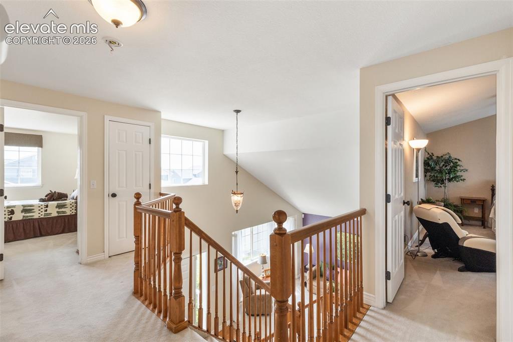 Image 19 of 47: Open loft at top of stairs, overlooking entry.
