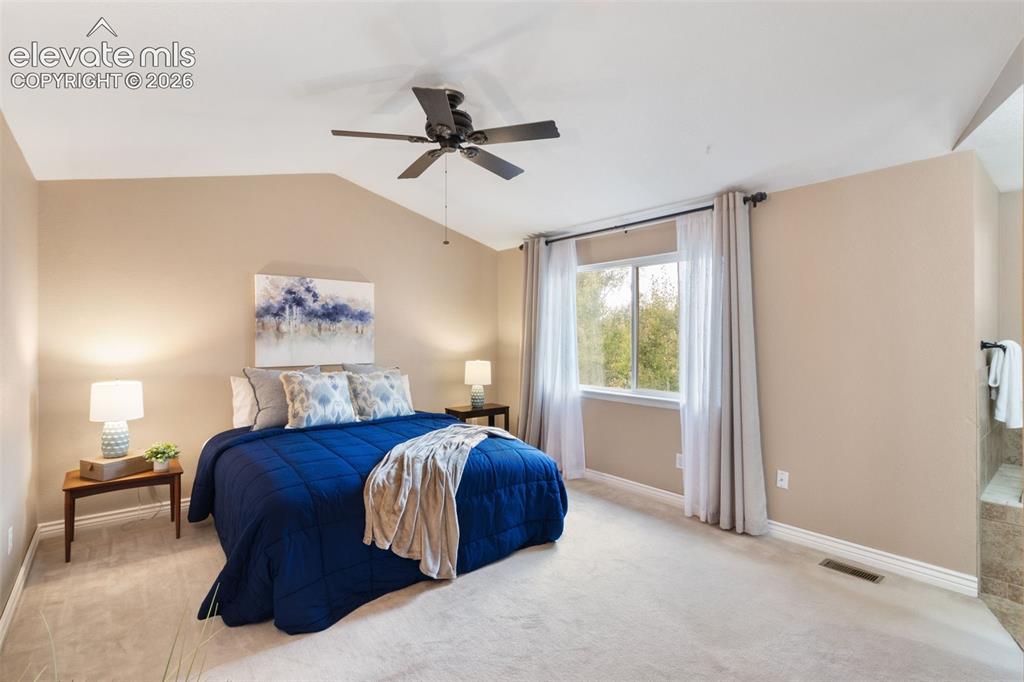 Image 22 of 50: Large primary bedroom upstairs with vaulted ceiling