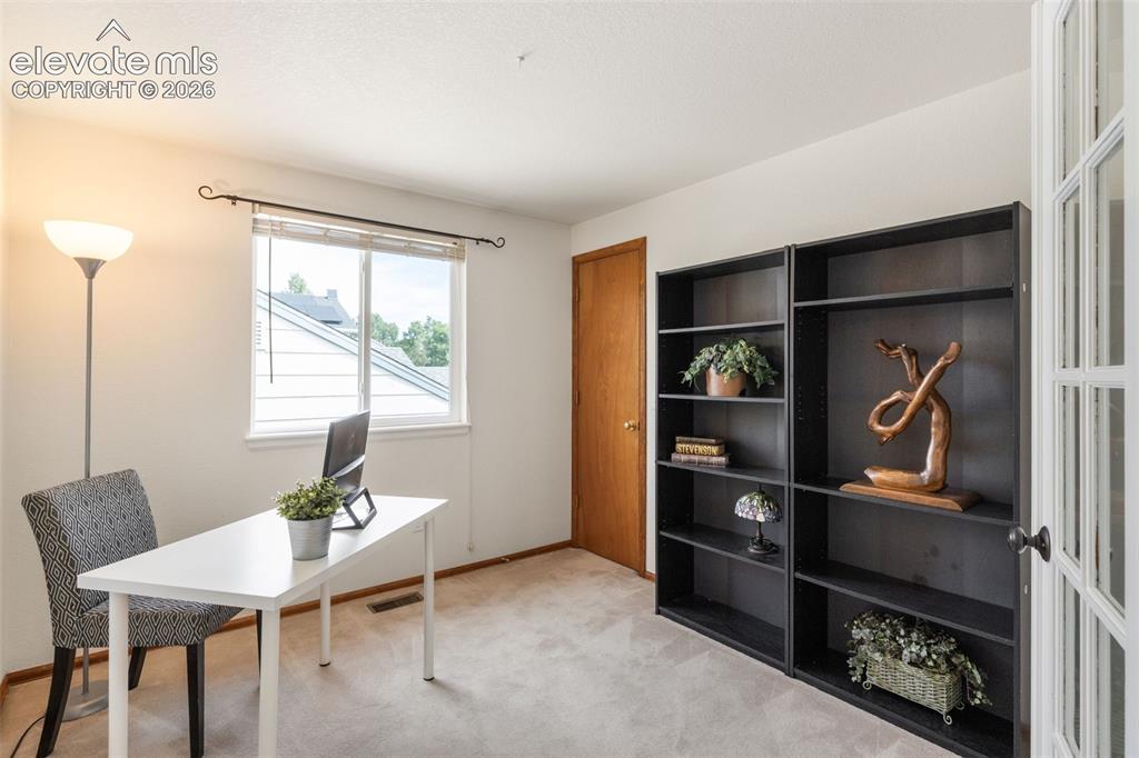 Image 26 of 47: Upstairs third bedroom, currently used as an office, and walk-in closet.