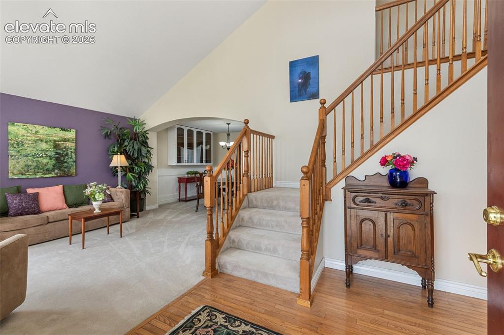 Image 3 of 47: Entryway with dramatic staircase and hardwood floor.