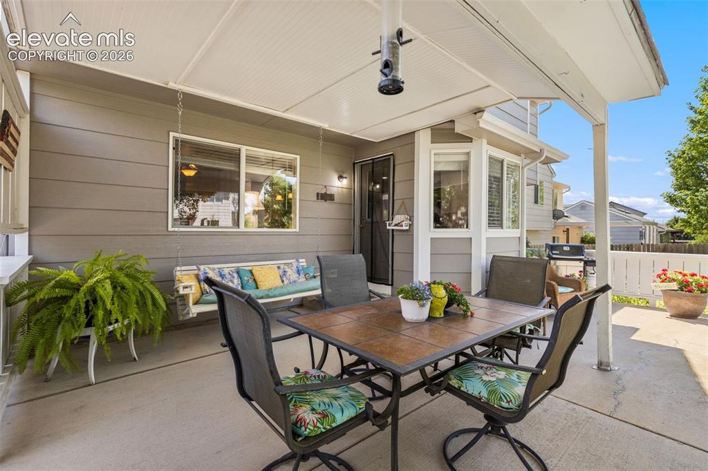 Image 36 of 47: harming covered patio off kitchen. Mature tree provides canopy and stunning