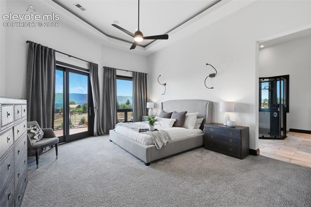 Image 21 of 48: Main level private master bedroom retreat with views, walk out to deck and