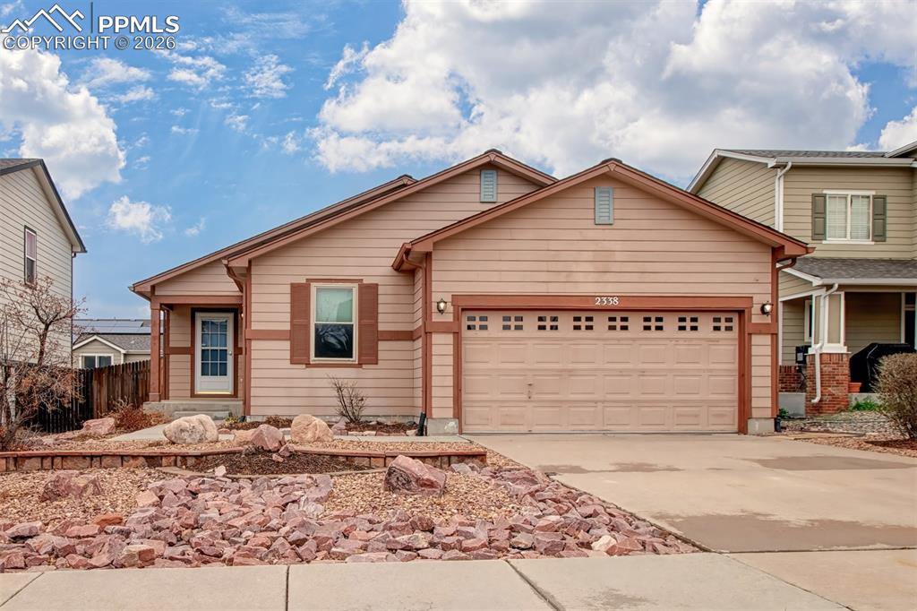Caption: View of front of home featuring an attached garage and concrete driveway