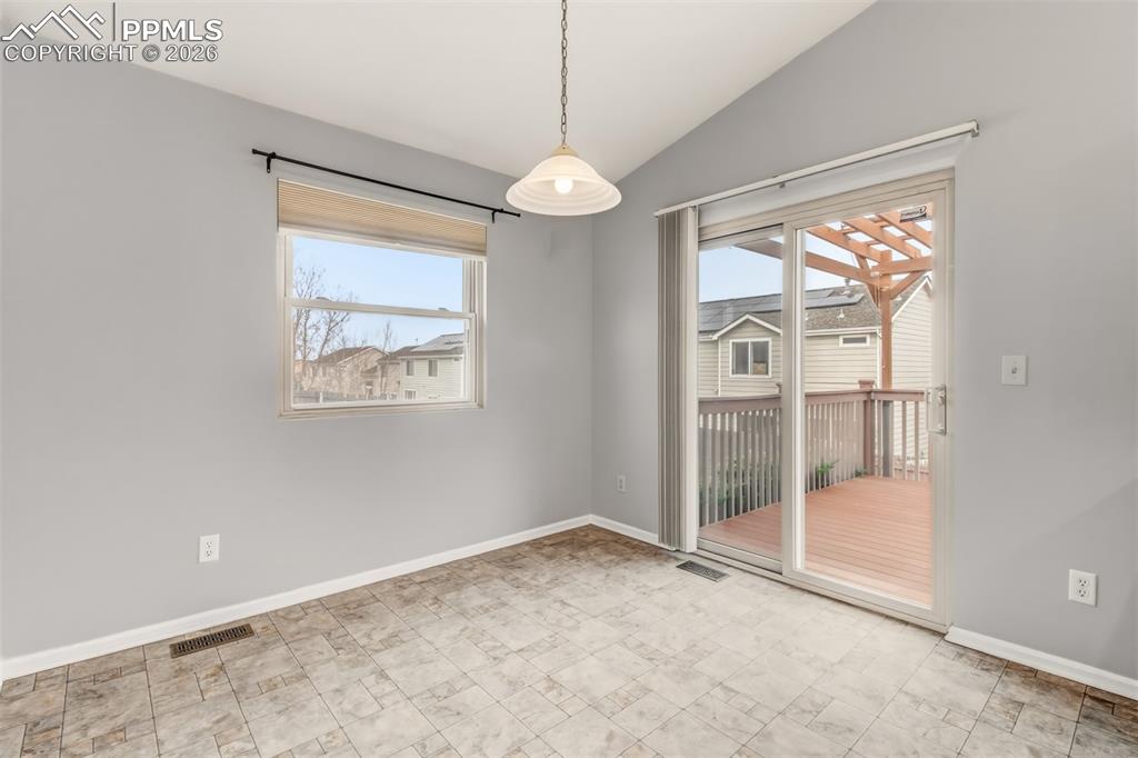 Image 10 of 27: Dining room featuring vaulted ceiling and walk-out