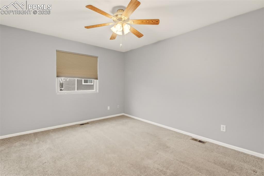 Image 11 of 27: Master bedroom with light colored carpet, window blinds, and a ceiling fan