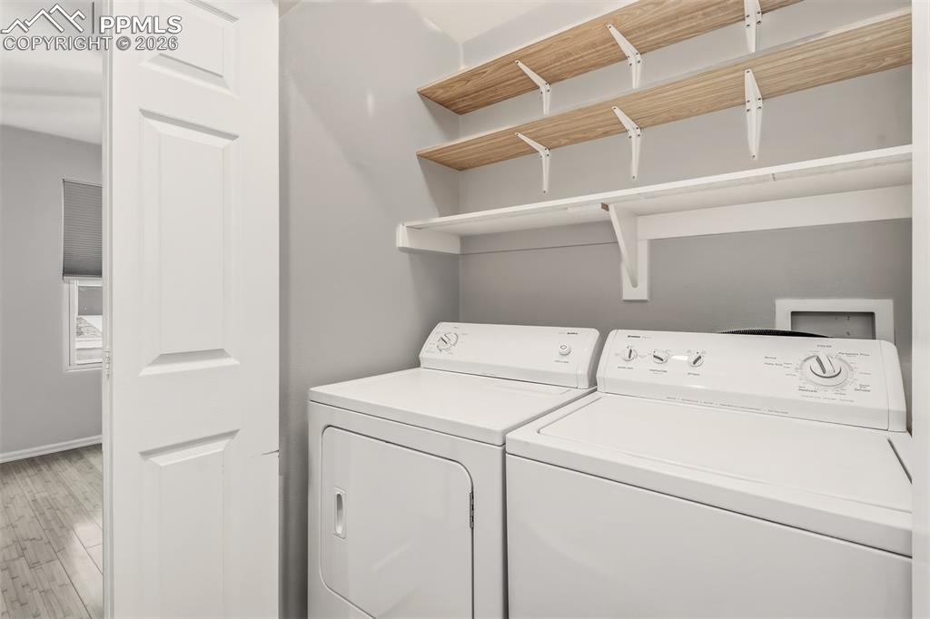 Image 18 of 27: Laundry area with light wood-type flooring and independent washer and dryer
