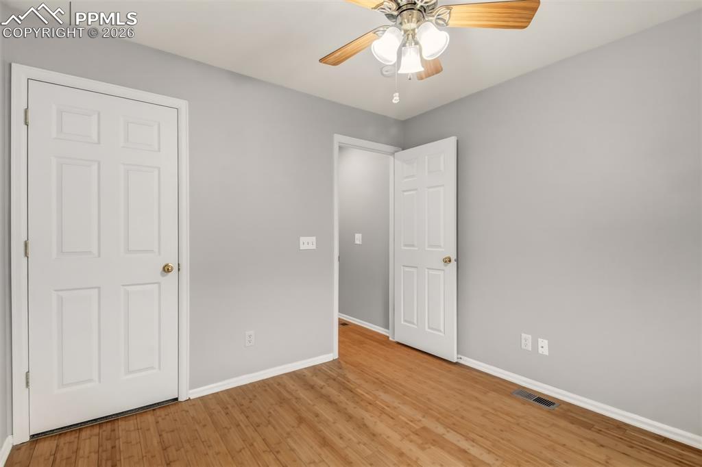 Image 20 of 27: Bedroom 3 featuring light wood finished floors , a walk in closet, and a ce