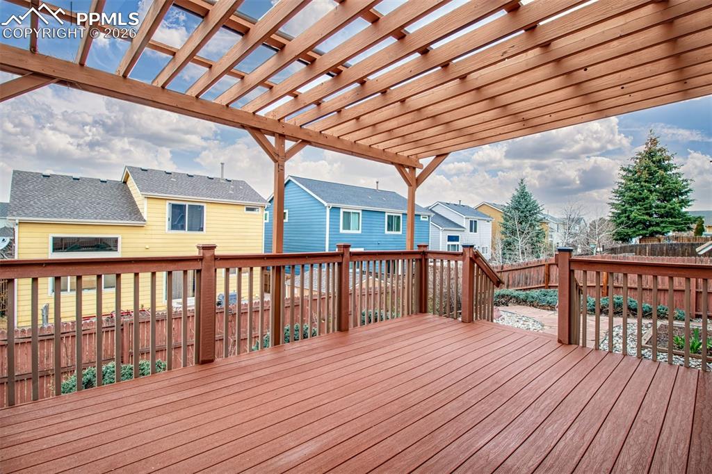 Image 21 of 27: Wooden terrace with a fenced backyard and a residential view
