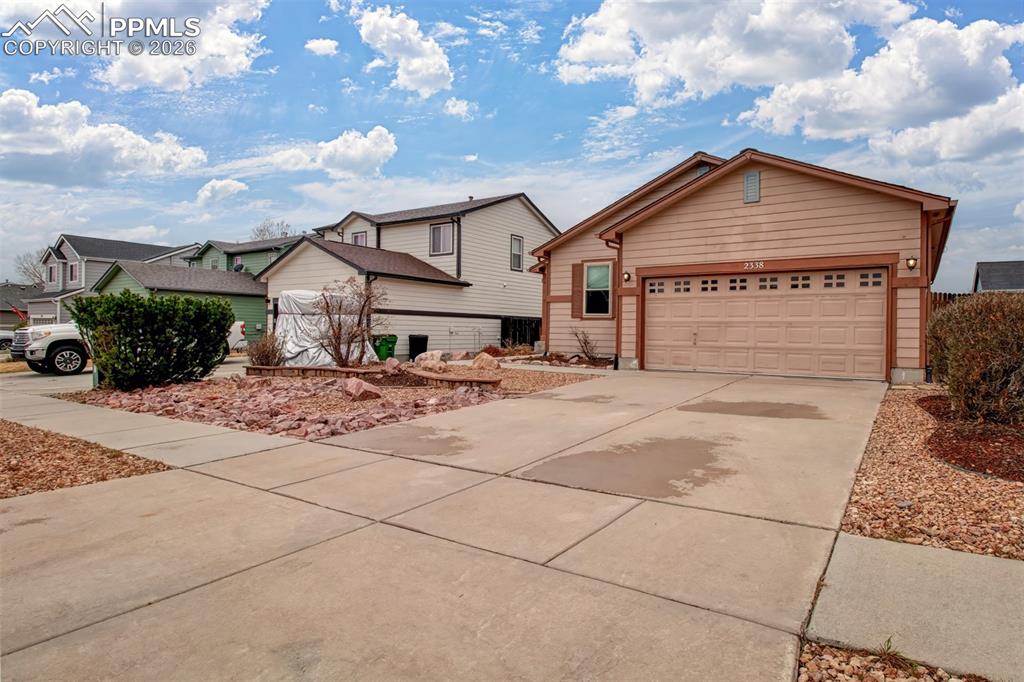 Image 3 of 27: View of front of property featuring driveway and a garage