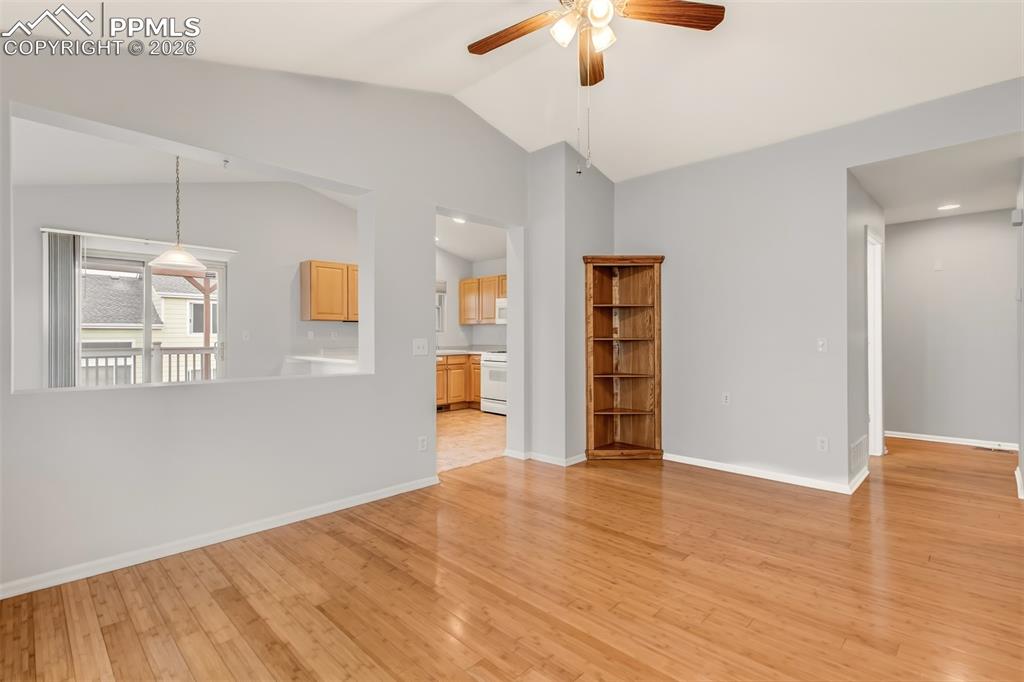 Image 5 of 27: Spare room featuring a ceiling fan, light wood finished floors, and vaulted