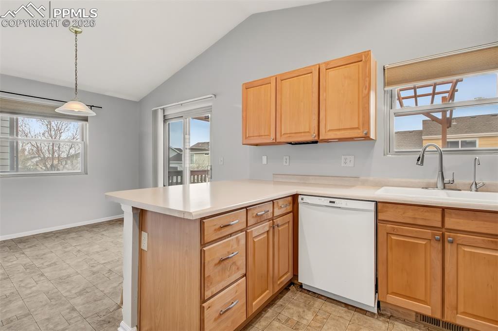 Image 7 of 27: Kitchen featuring clean white appliances, light countertops, natural gas ra