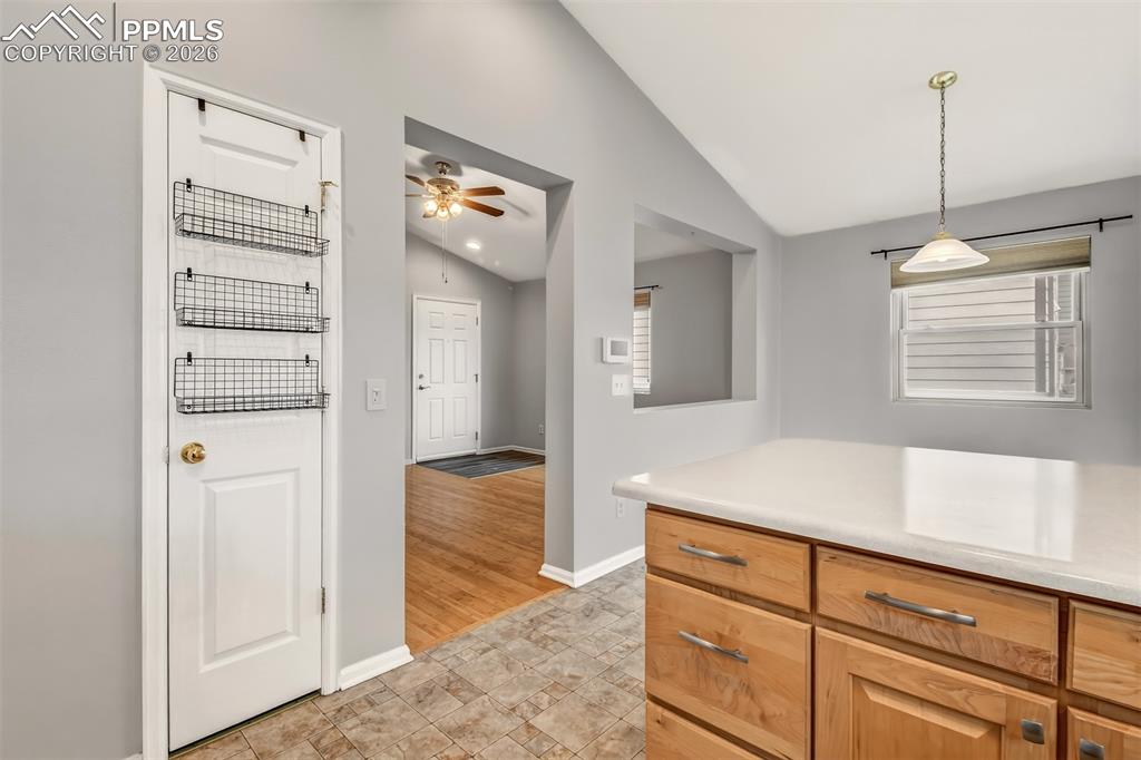 Image 8 of 27: Kitchen with light countertops, lofted ceiling, ceiling fan, and decorative