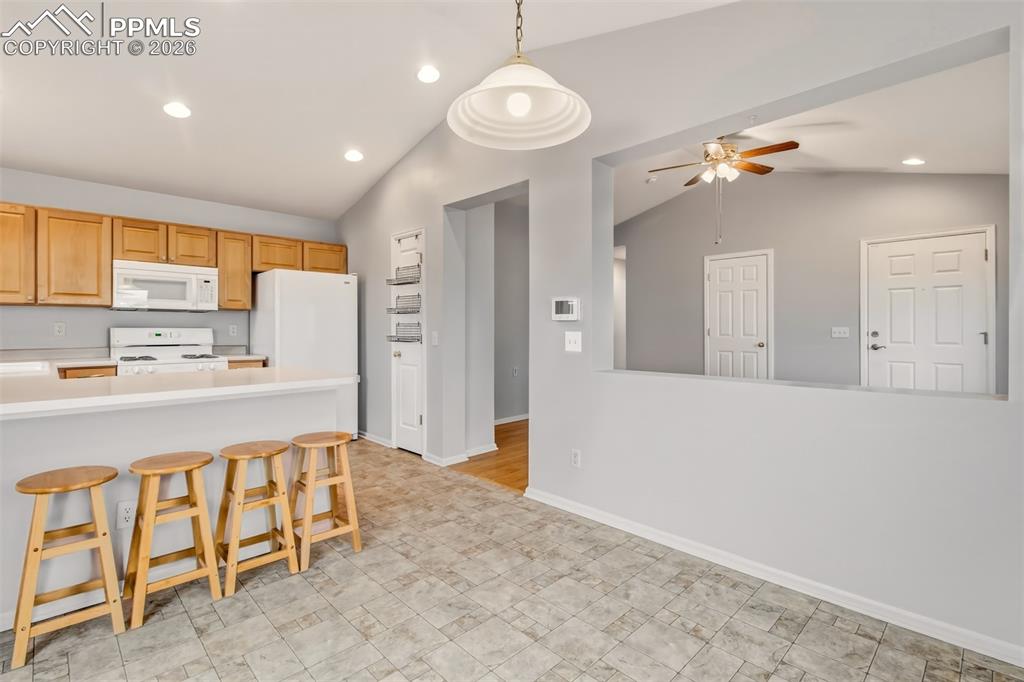 Image 9 of 27: Kitchen/dining area with light countertops, decorative light fixtures, whit