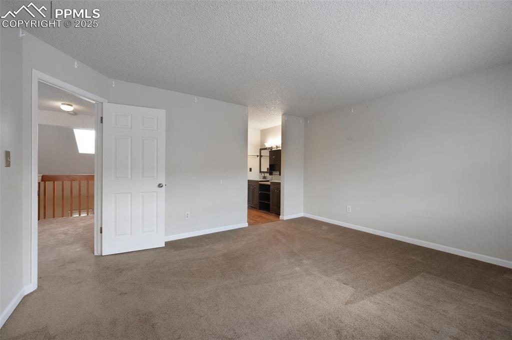 Image 13 of 39: Primary bedroom with adjoining bath