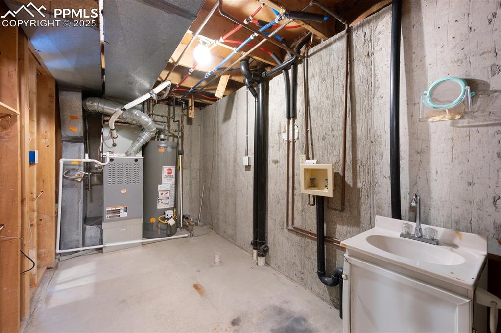 Image 27 of 39: unfinished basement area with laundry hookups and rough-in for bath.
