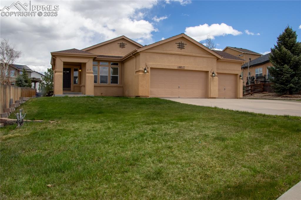 Caption: View of front of property featuring a garage, driveway, and stucco siding