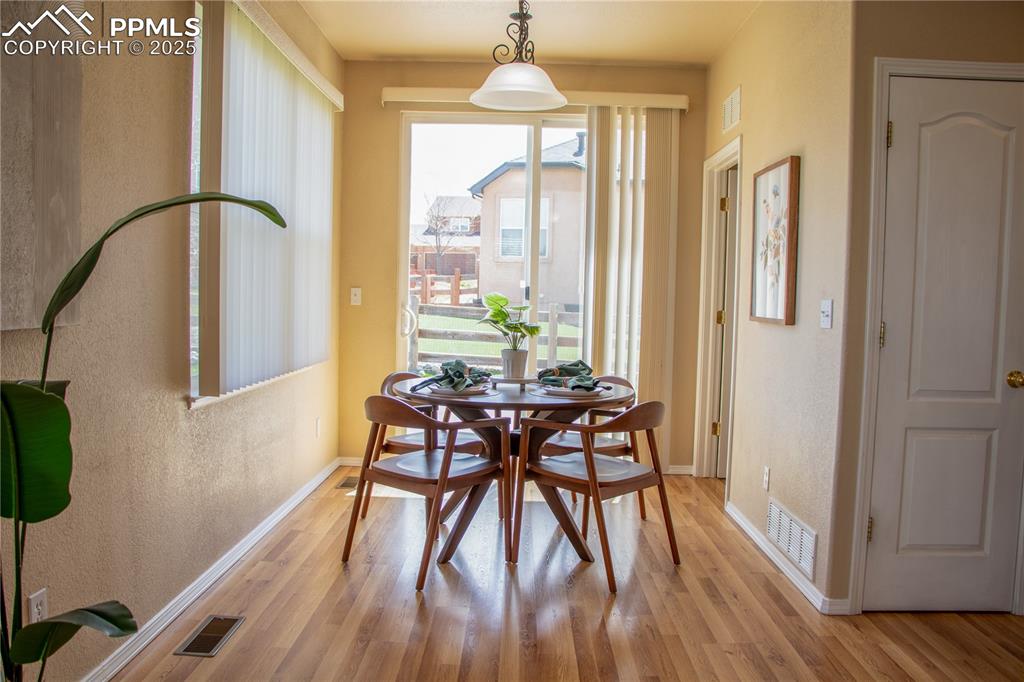 Image 12 of 31: Dining room with wood finished floors and a textured wall