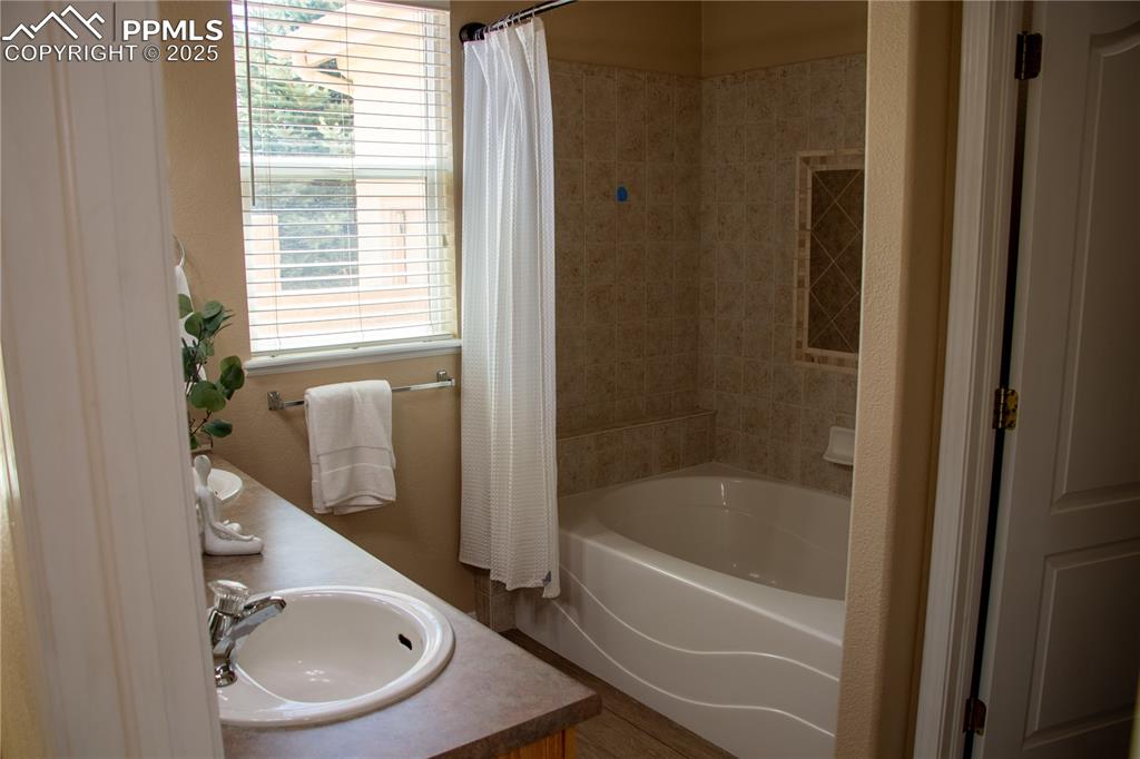 Image 15 of 31: Bathroom with shower / tub combo and double vanity