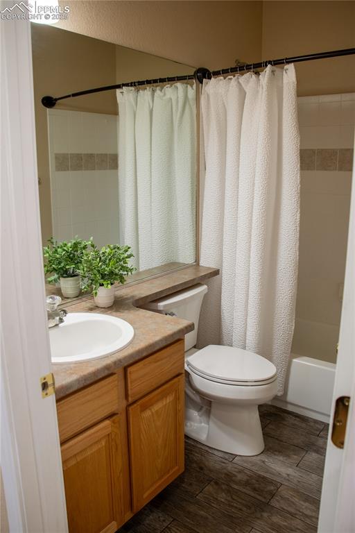 Image 16 of 31: Bathroom with vanity, shower / tub combo, and wood finished floors