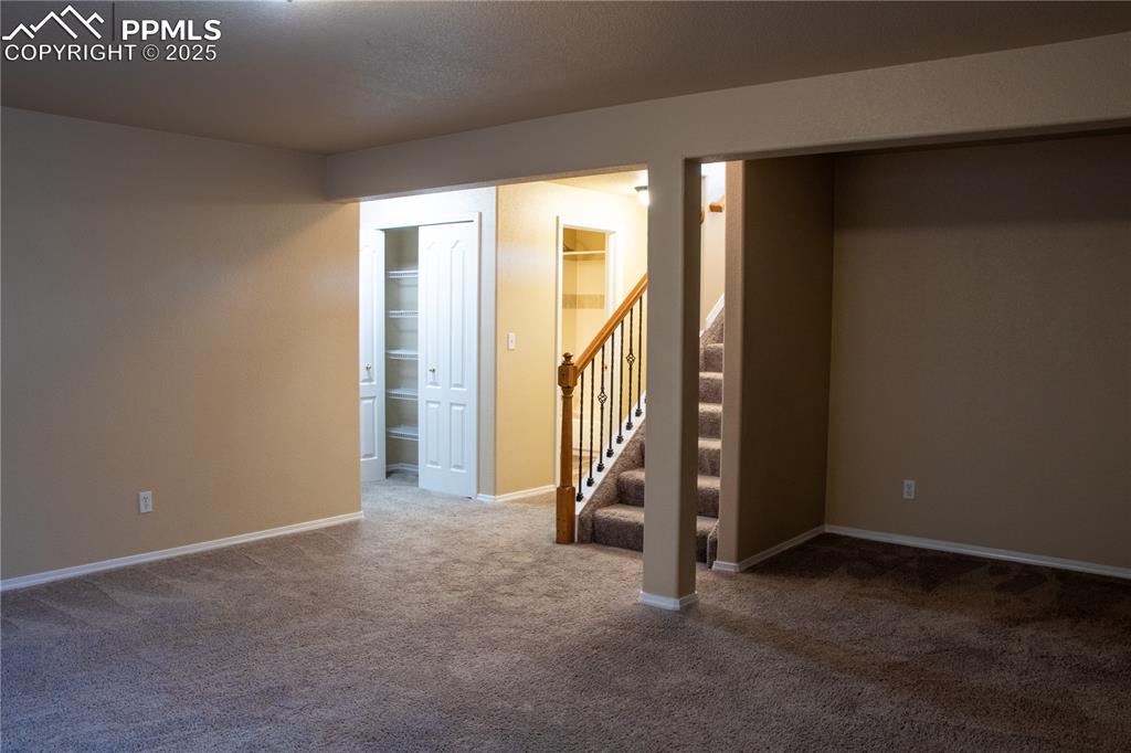 Image 19 of 31: Basement with carpet floors and stairs