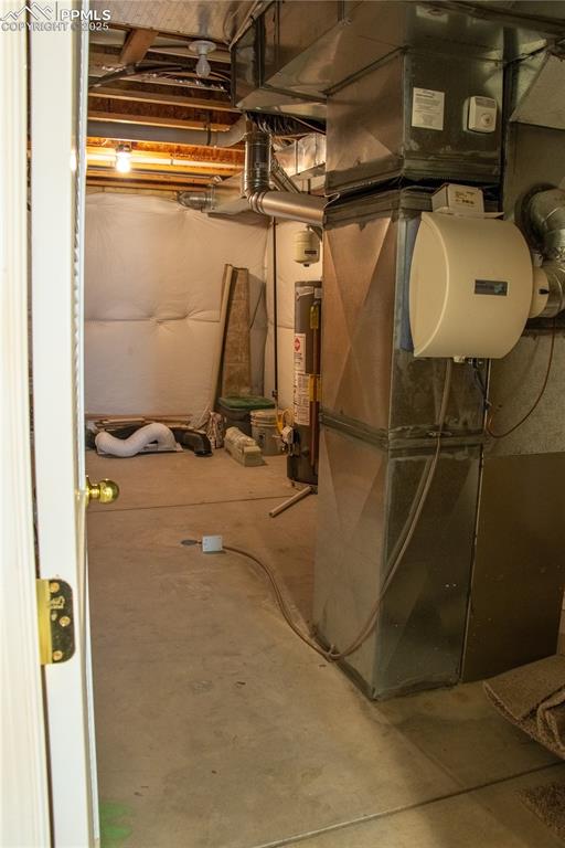 Image 26 of 31: Unfinished basement with water heater and heating unit