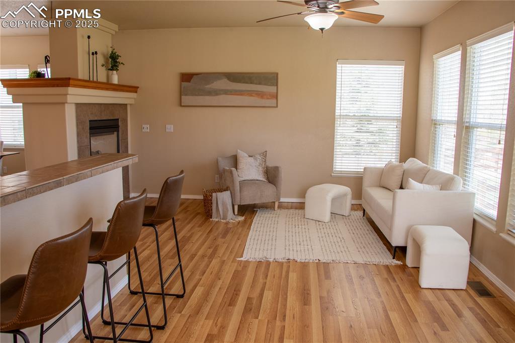 Image 7 of 31: Living area with a ceiling fan, light wood-style flooring, healthy amount o