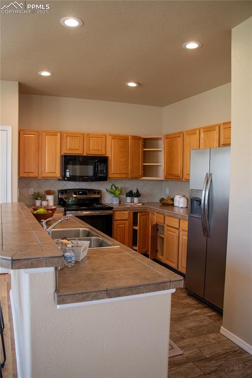 Image 9 of 31: Kitchen with appliances with stainless steel finishes, dark wood-type floor