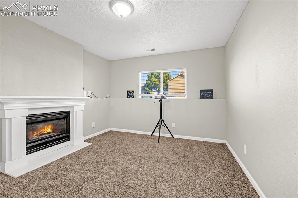 Image 17 of 35: Lower level family room with fireplace