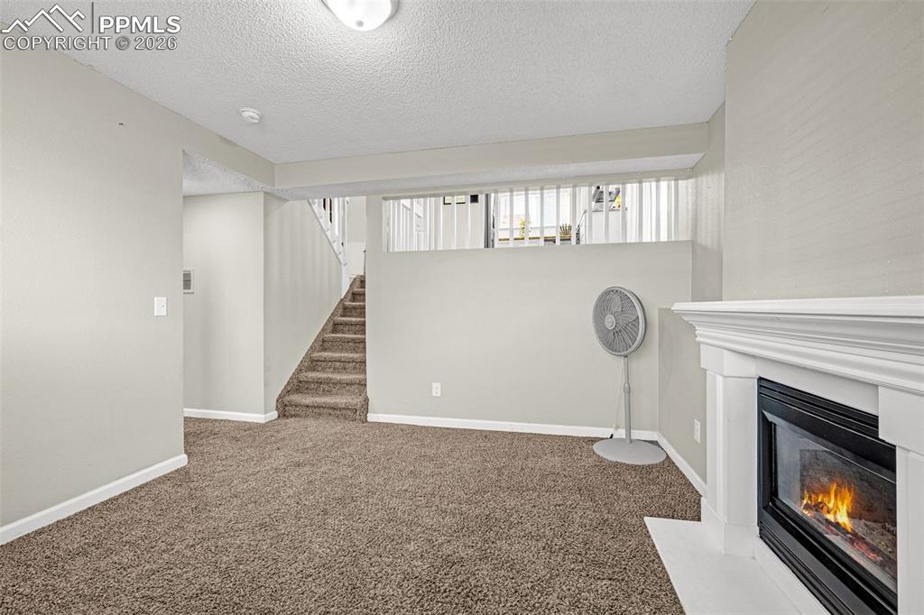 Image 22 of 35: Lower level family room with fireplace