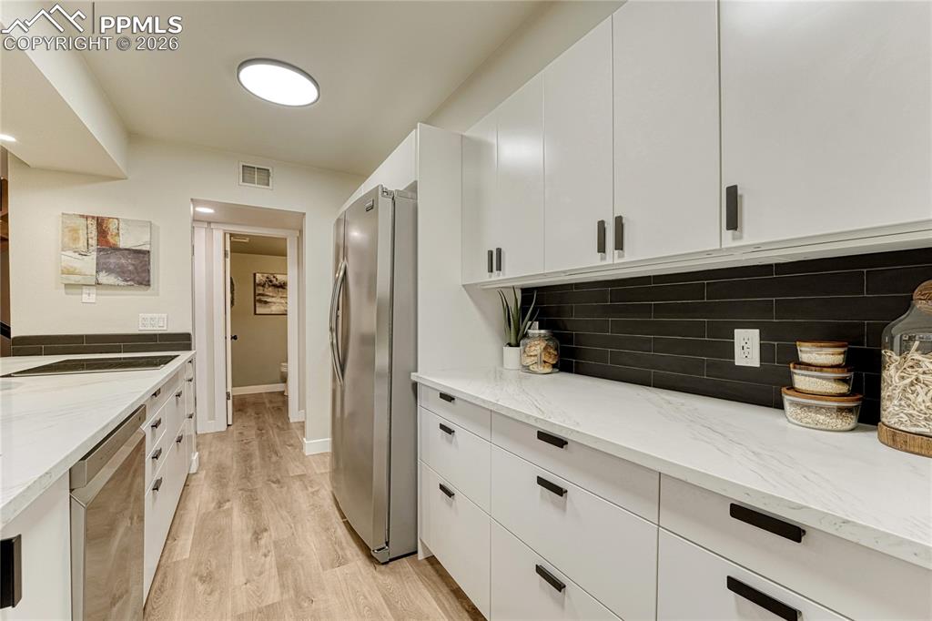 Image 19 of 50: At the end of the kitchen is the laundry room and garage door entry