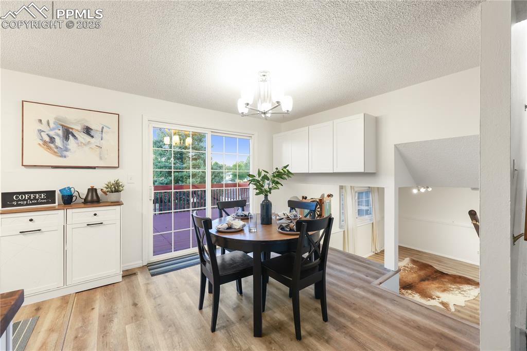 Image 16 of 32: Dining space featuring a textured ceiling, light wood finished floors, and 