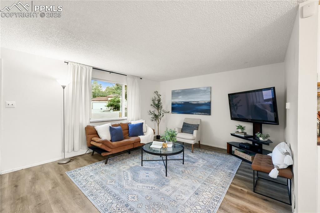 Image 5 of 32: Living room with a textured ceiling and light wood finished floors