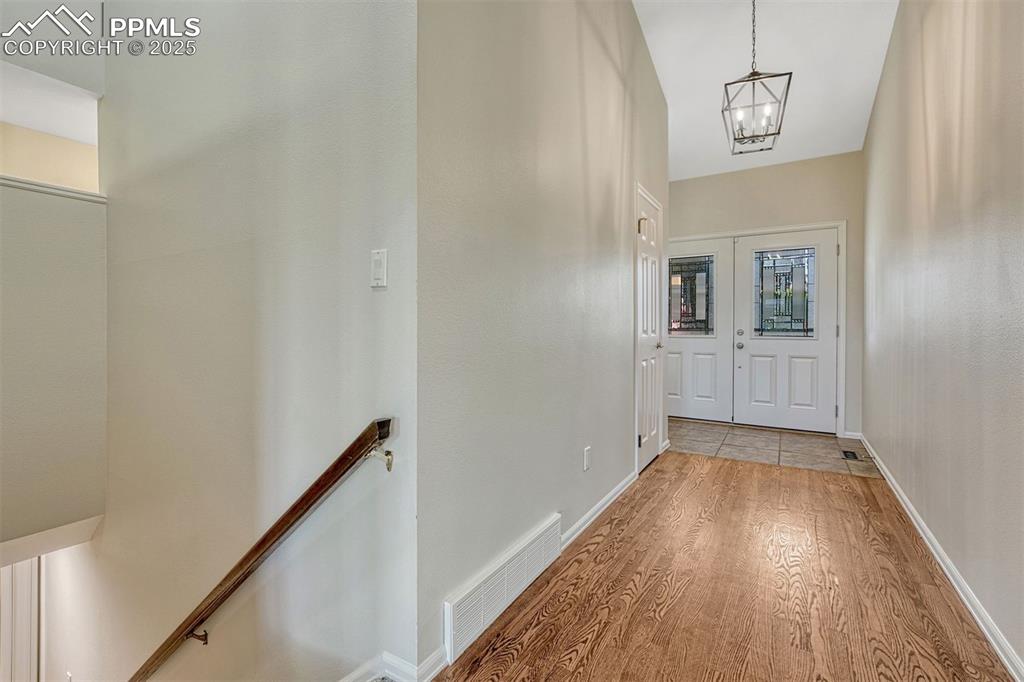 Image 11 of 50: Hardwood floors and tall ceiling in the entry hallway.