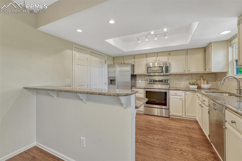 Image 12 of 50: Hardwood floors continue into the kitchen.
