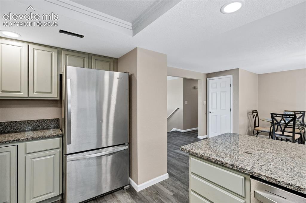 Image 10 of 46: Kitchen featuring light-toned cabinetry, speckled countertops, and stainles