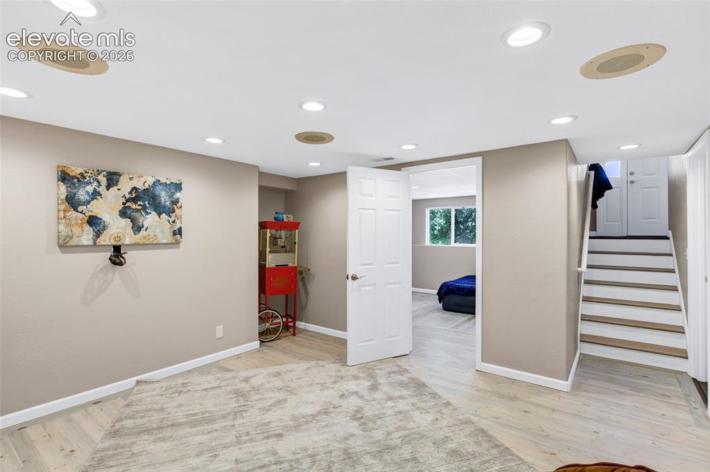 Image 23 of 46: Spacious room featuring light wood-finish flooring, recessed lighting, and 