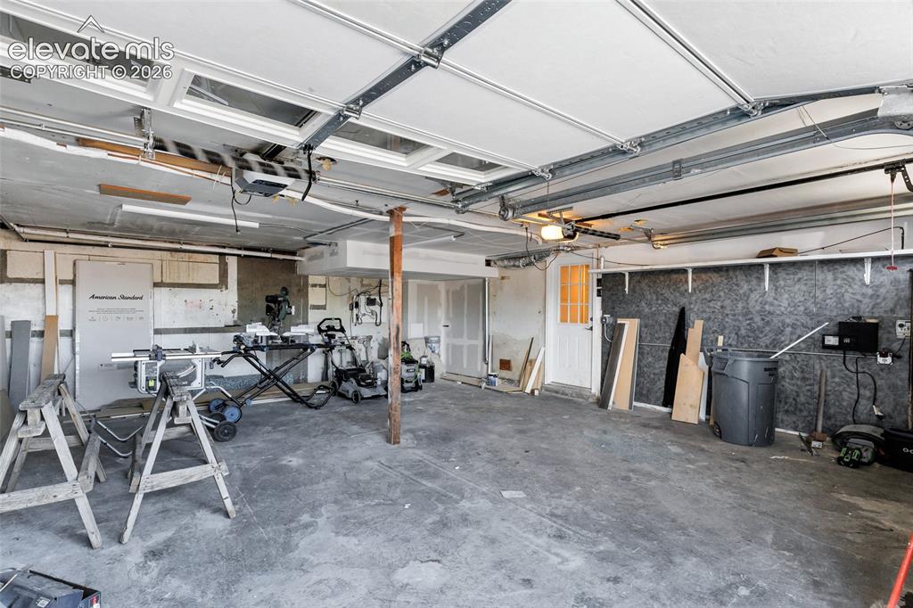 Image 26 of 46: Utility space featuring a Brand New tankless water heater, wood-finish floo