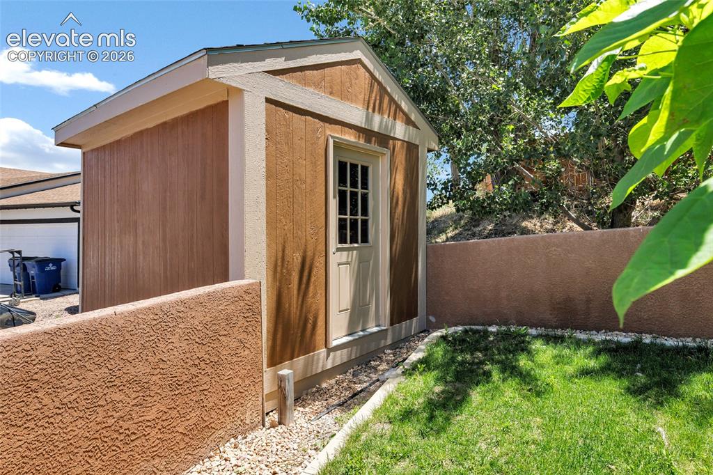 Image 31 of 46: Private fully fenced backyard featuring a mature shade tree, a 42