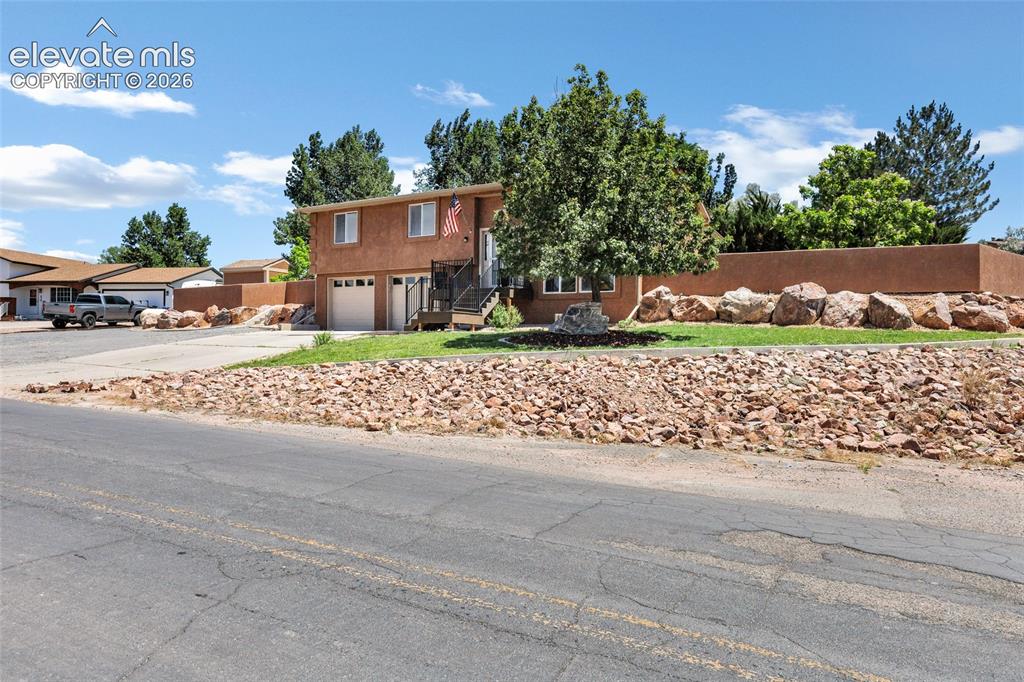 Image 34 of 46: Split-level residence featuring a stucco exterior, attached two-car garage,